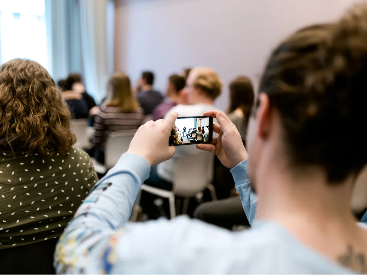 Teilnehmerin fotografiert im Workshop mit dem Smartphone den Raum