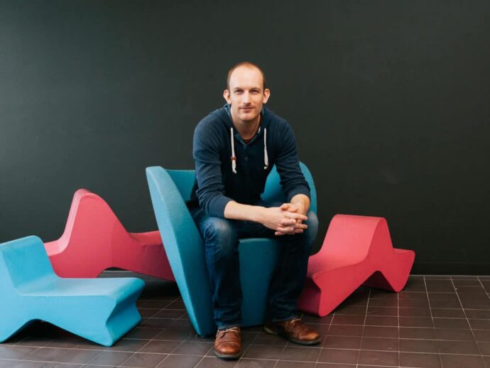Portrait von Franz Seher in der Tabakfabrik Linz, sitzend auf Designermöbeln, Pressefotografie